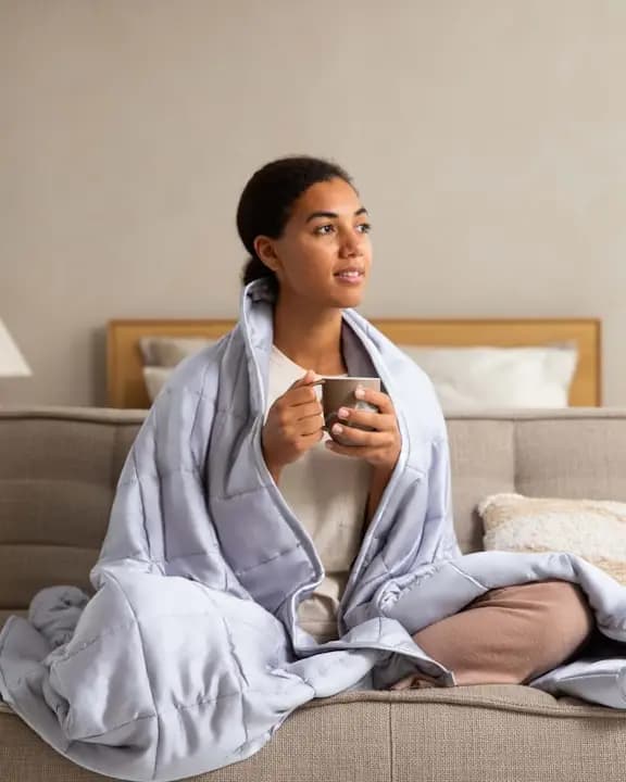 A woman relaxing on a sofa with a mug